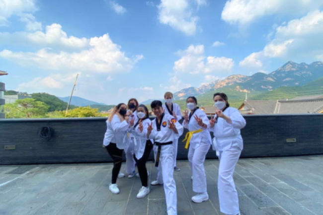 Seven students on roof top doing taekwondo