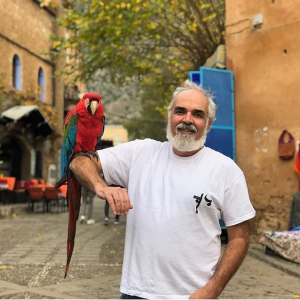 Photo of Christopher Wise with a parrot on his right arm
