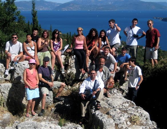 group of students on a rock in Greece with water in background